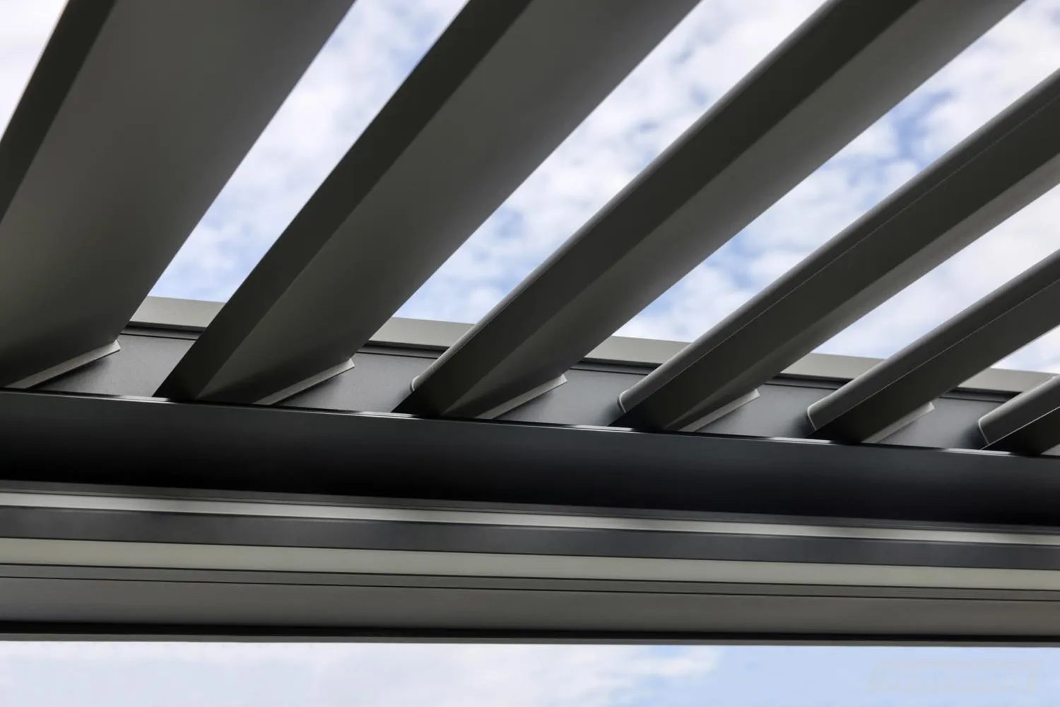 Geöffnete drehbare Aluminium-Lamellen eines Warema Lamaxa L60 von unten gegen den Himmel