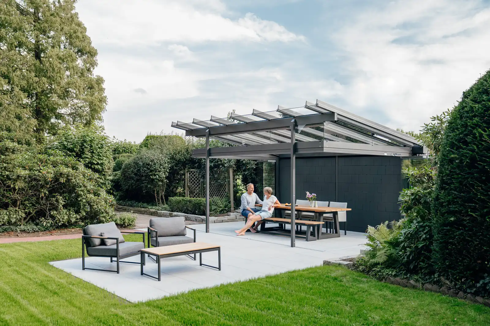 Freistehender Sitzplatz im Garten unter einem Solarlux SDL Atrium Plus mit offener Front