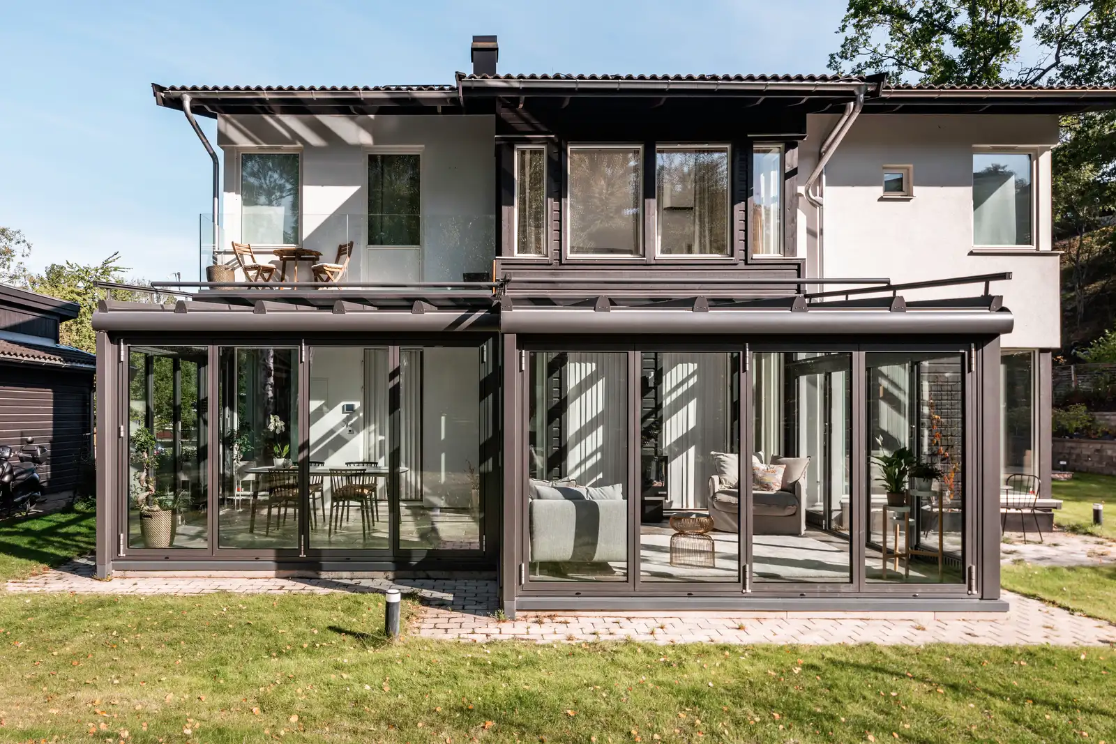 Anthrazitfarbener Wintergarten Solarlux SDL Akzent Plus unter dem Balkon eines modernen Wohnhauses