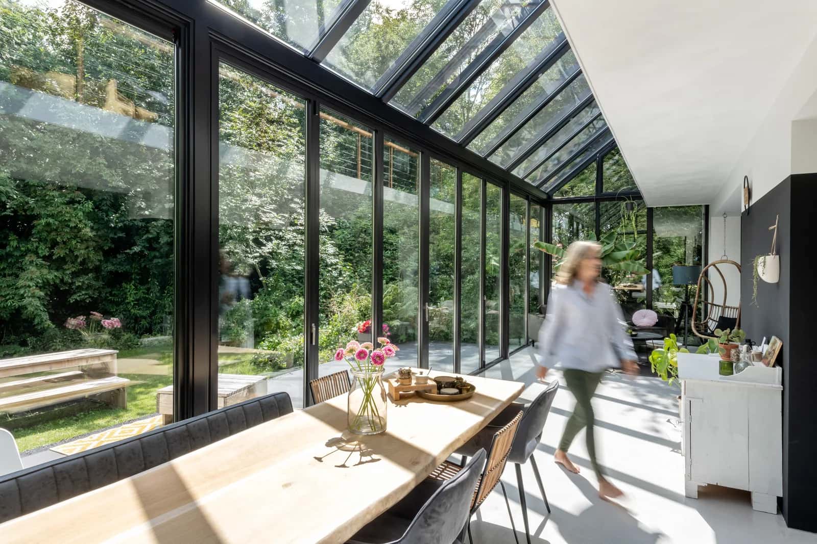 Heller Wohn-Wintergarten SDL Akzent Plus von innen mit Glasdach und Blick in den sommerlichen Garten
