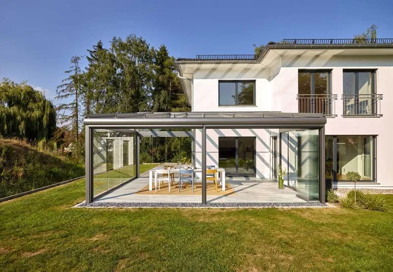 Terrassendach SDL Atrium Plus mit Glas-Faltwänden an einer weißen Villa in Laupheim