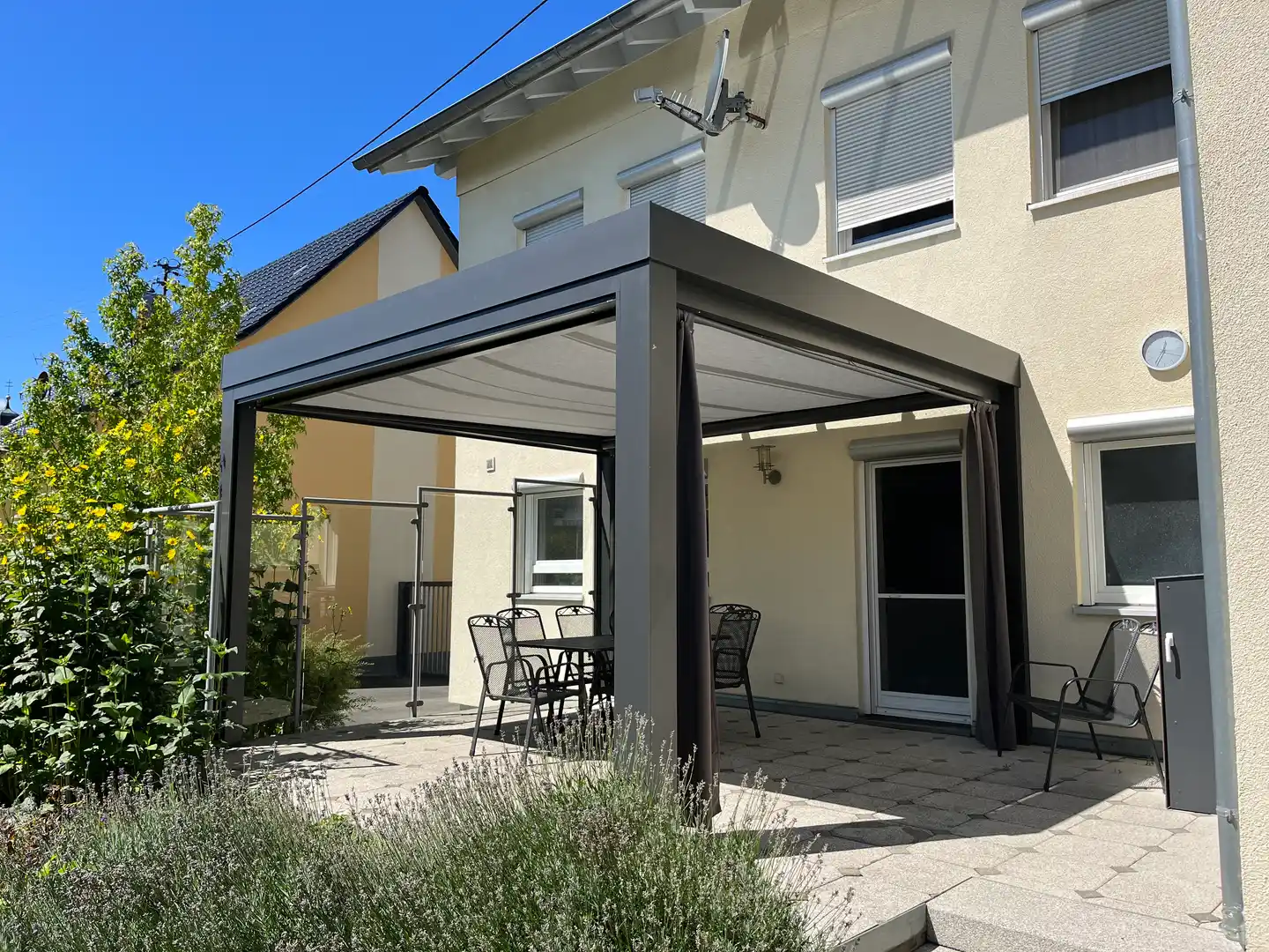 Flaches kubisches Terrassendach mit ausgefahrener Unterglasmarkise und Lavendel im Vordergrund im Raum Herbertingen
