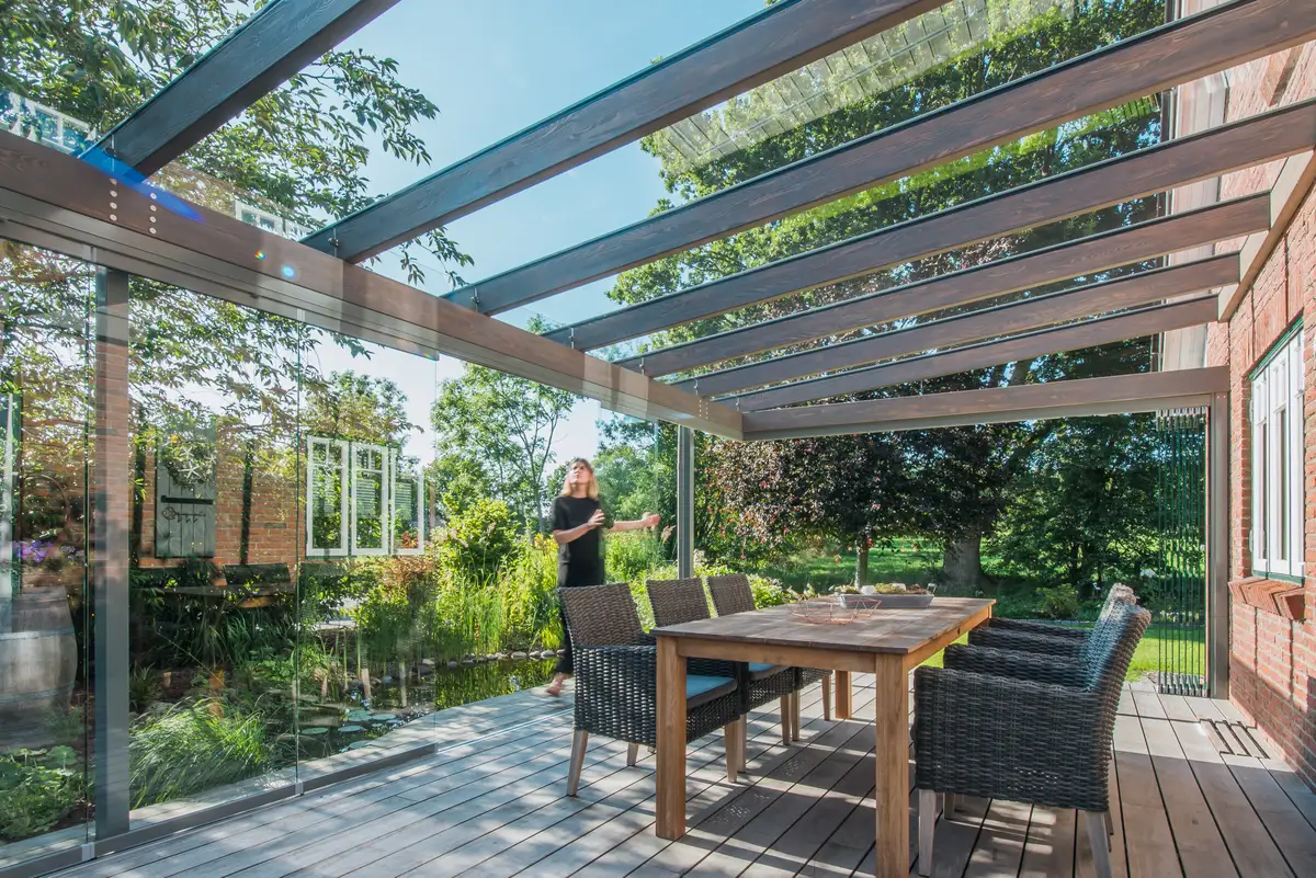 Untersicht eines Terrassendachs in Holz-Aluminium-Bauweise: dunkle Holzsparren unter dem Glasdach, darüber die schmalen Aluminium-Deckschalen