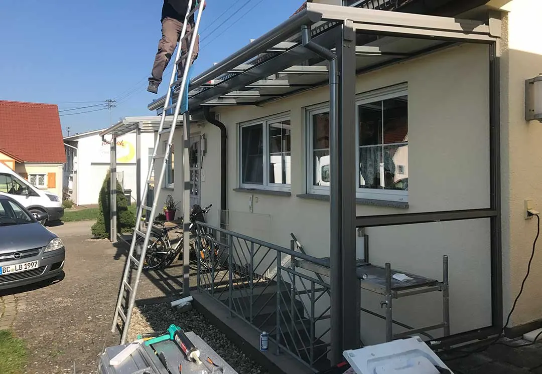 Das zweite Glasdach während der Montage, im Hintergrund die fertige Eingangsüberdachung