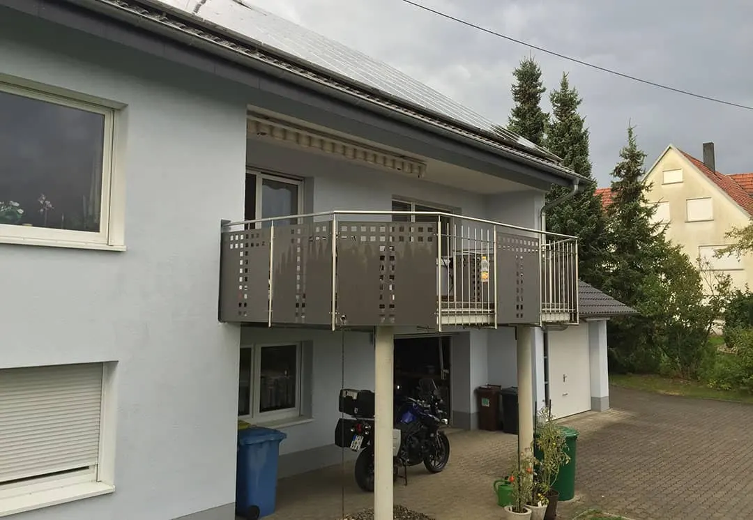 Der Balkon vor dem Umbau: offen über der Garageneinfahrt, mit Lochblech-Geländer und gestreifter Markise über der Balkontür