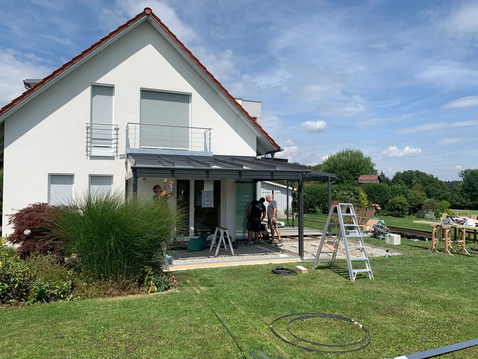Das Glasdach wird unter dem bestehenden Balkon an das Haus angeschlossen