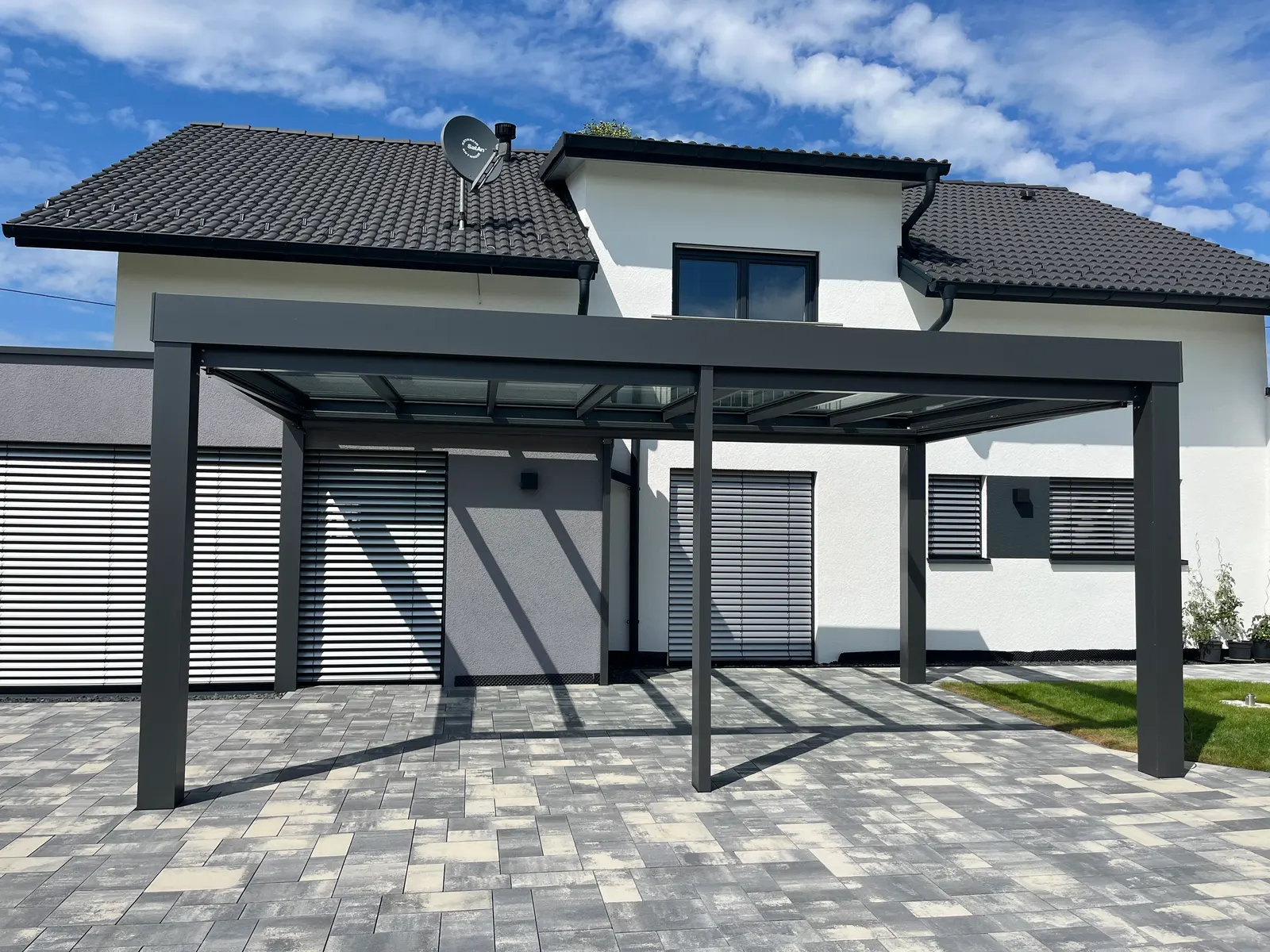 Das freistehende Terrassendach von der Gartenseite, dahinter offene Felder