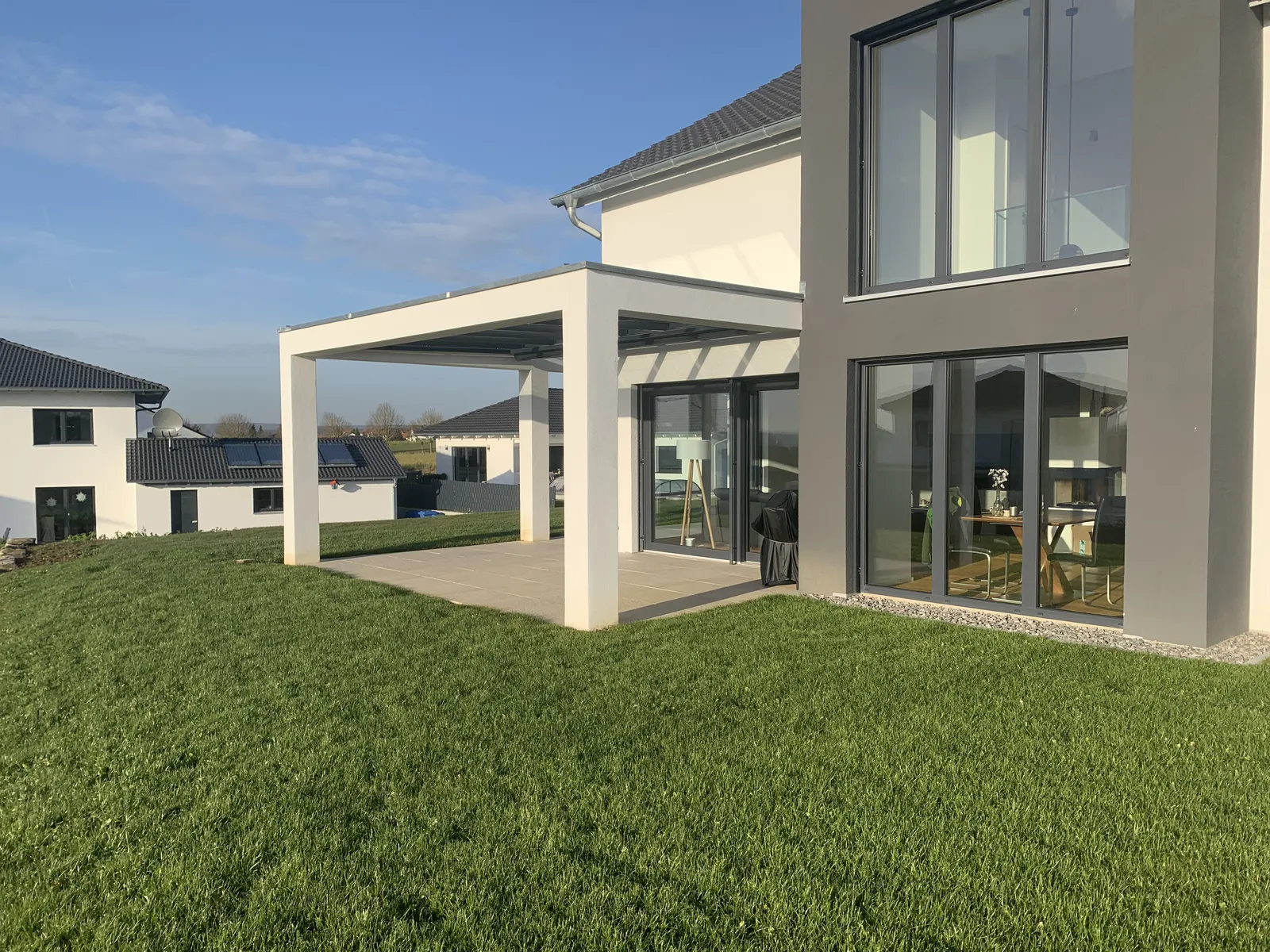 Das Terrassendach schräg von außen, das Glasdach liegt im weißen Rahmen des Hauses